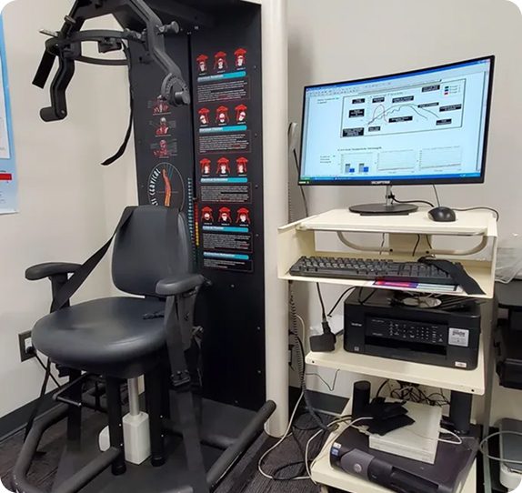 Medical testing chair with computer setup.