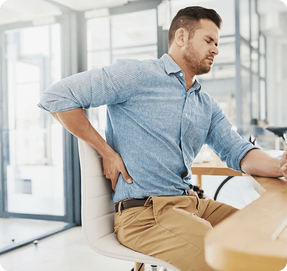 Man experiencing back pain while seated.