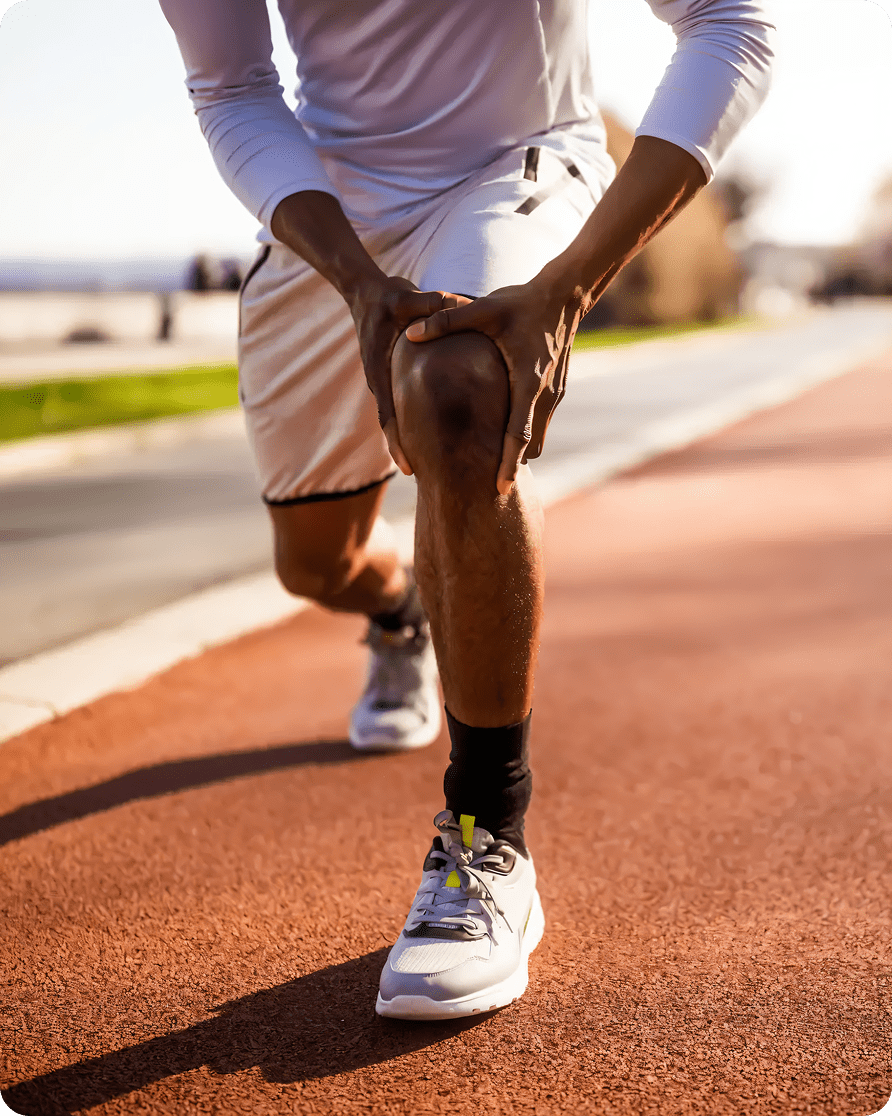 Runner stretching on a sunny track.